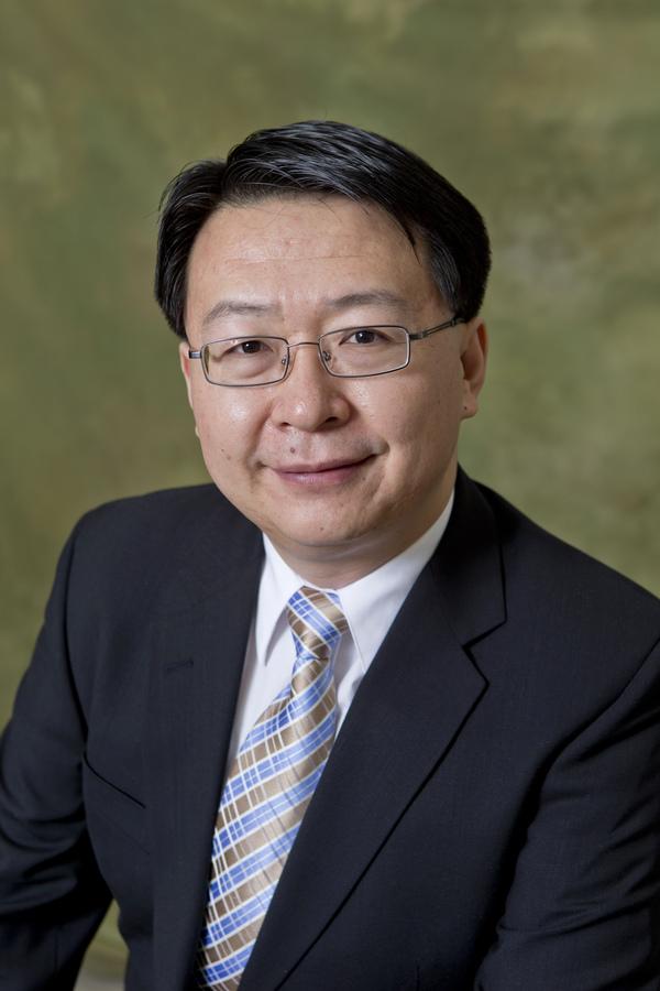 A headshot of Dennis Yu smiling.